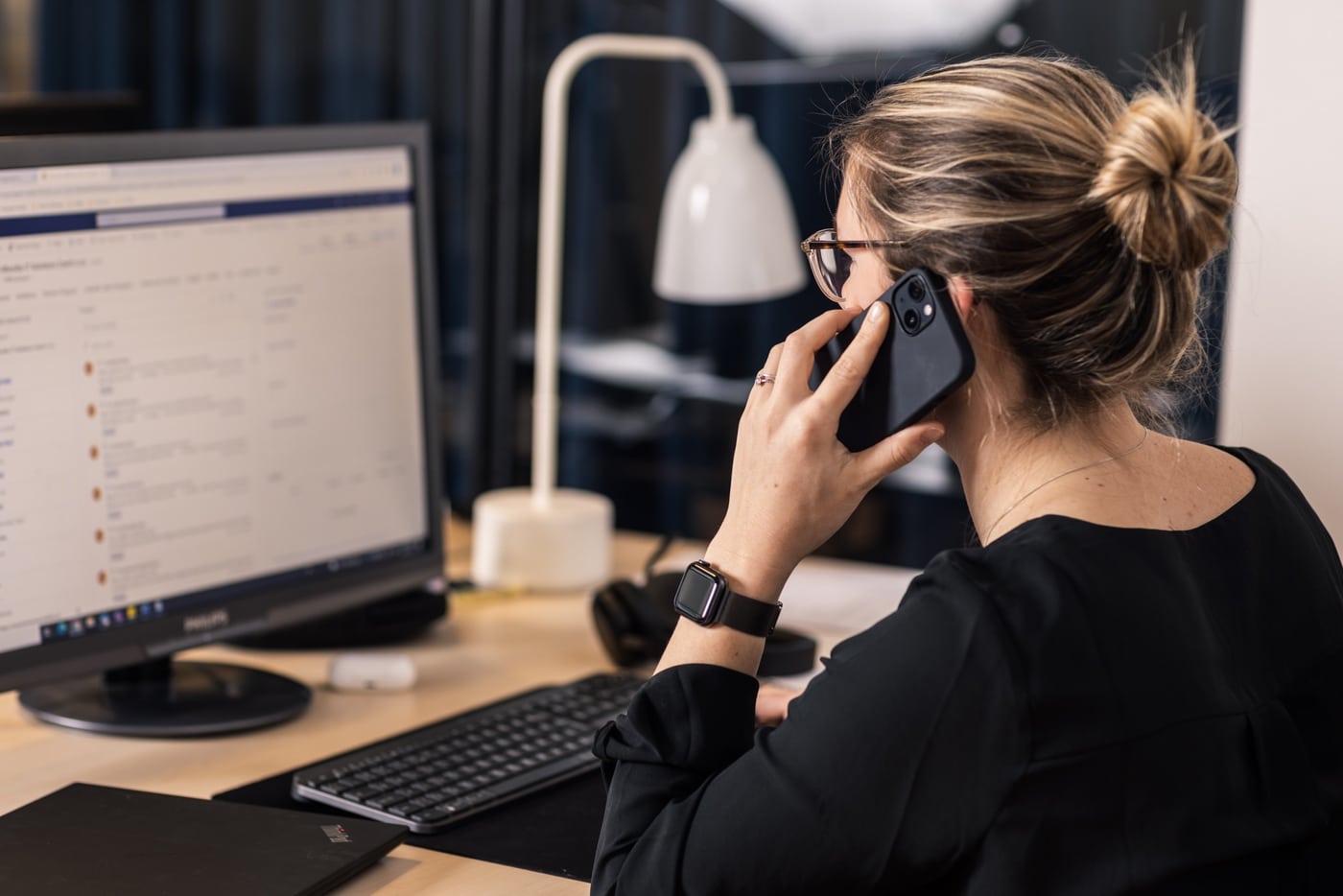 A Woman On The Phone At A Desk