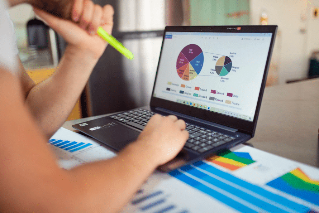 Person On A Laptop Looking At Reporting Documents