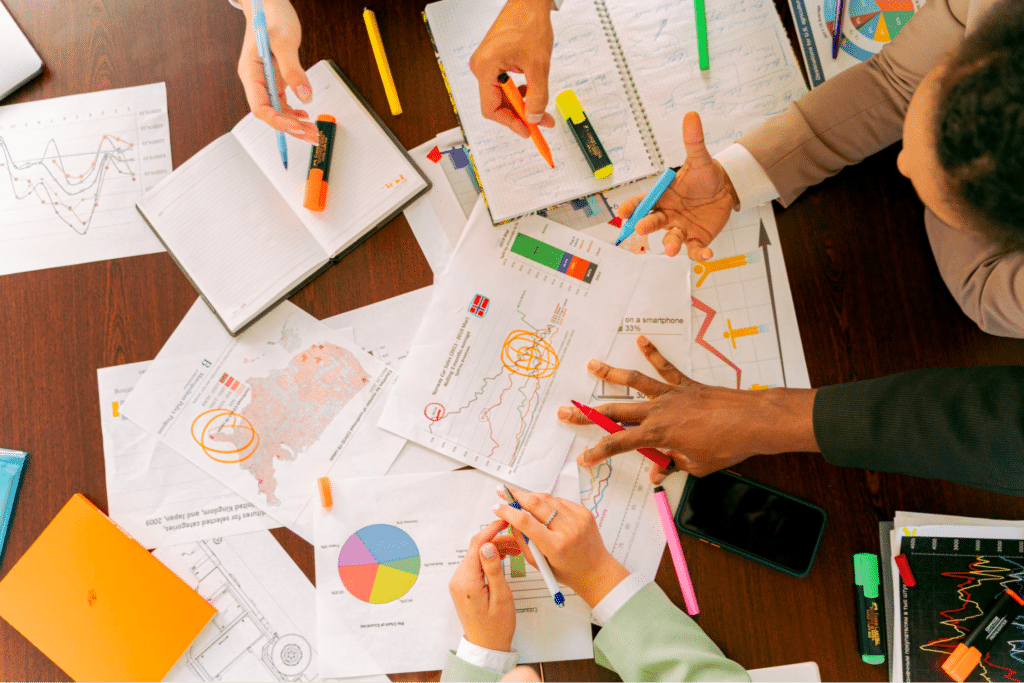 A Team Over A Table Analyzing A Lot Of Statistics