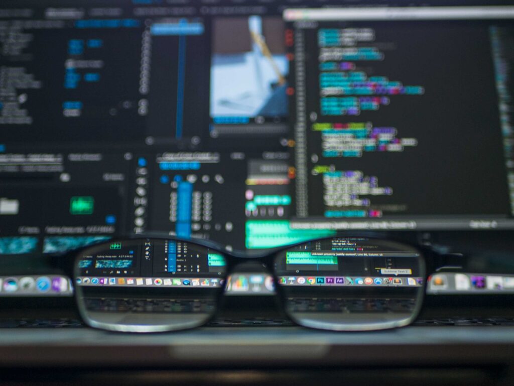 Glasses By A Laptop, Screen Showing Code