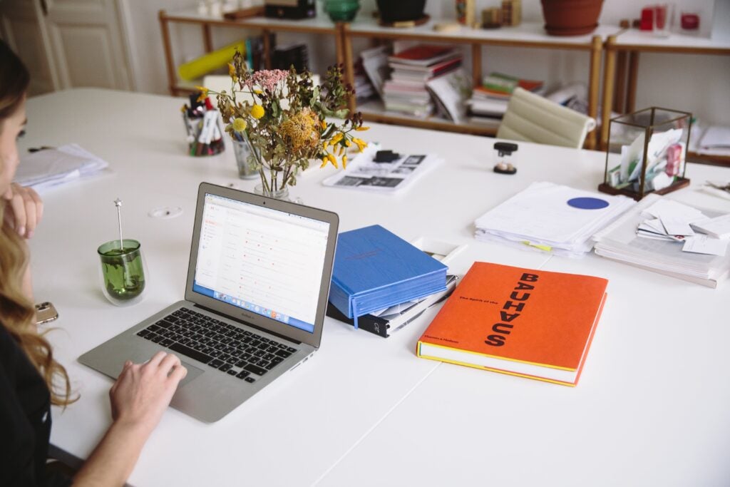 Woman Working On Documentation On A Laptop At A Desk