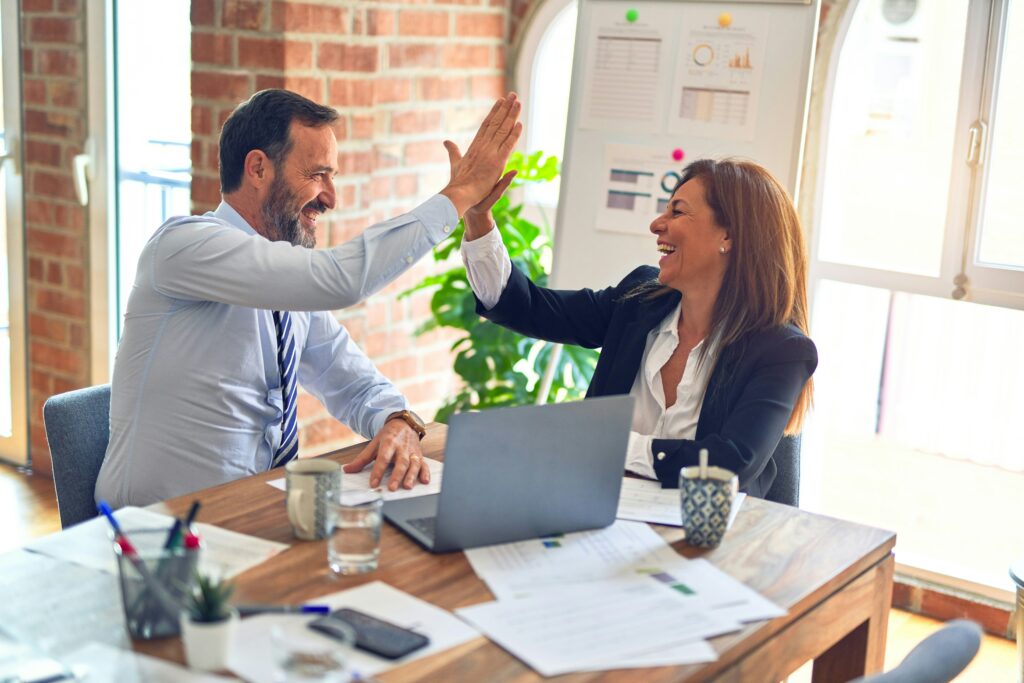 People High Fiving Each Other Happily In The Office